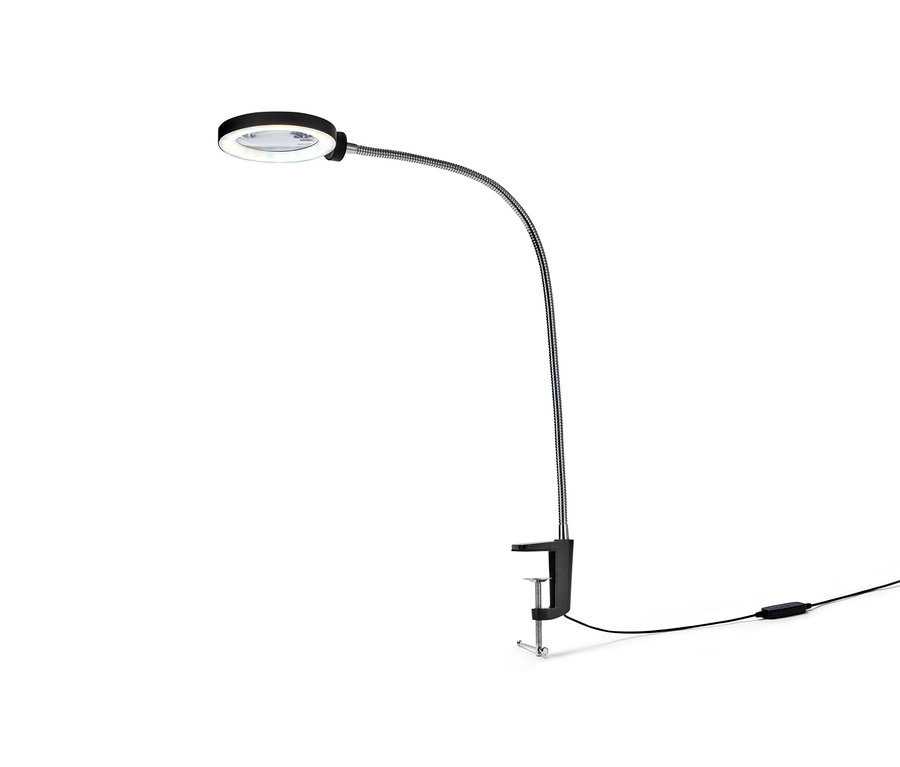 Eine schwarze Handarbeitslampe mit Lupe ist an einem Tisch befestigt.