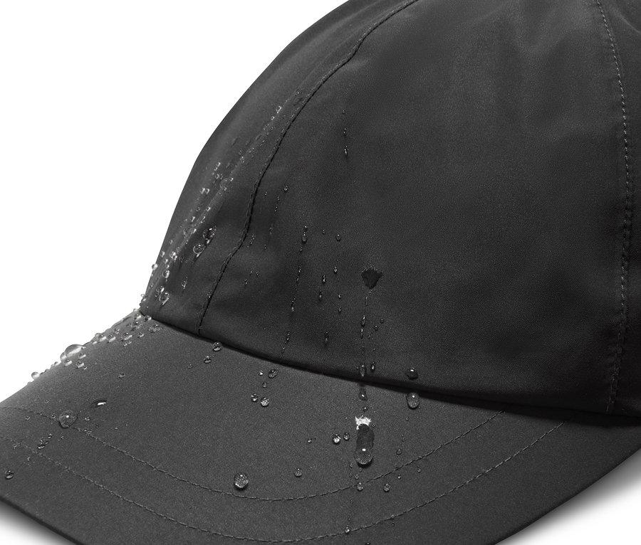 Detailaufnahme einer schwarzen Allwetter-Kappe mit Wassertropfen.