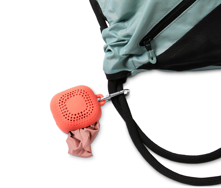 Ein Outdoor-Handtuch in einem orangefarbenen Etui hängt an einem Rucksack.