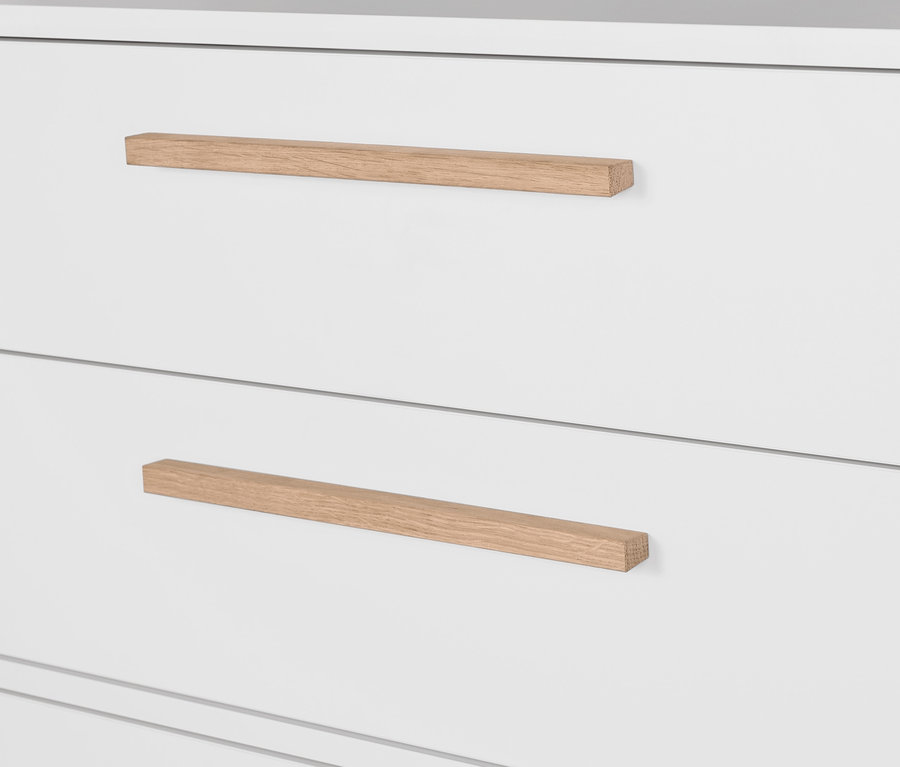 Detail einer weißen Kommode »Eklund« mit Ankleide und Holzgriffen.