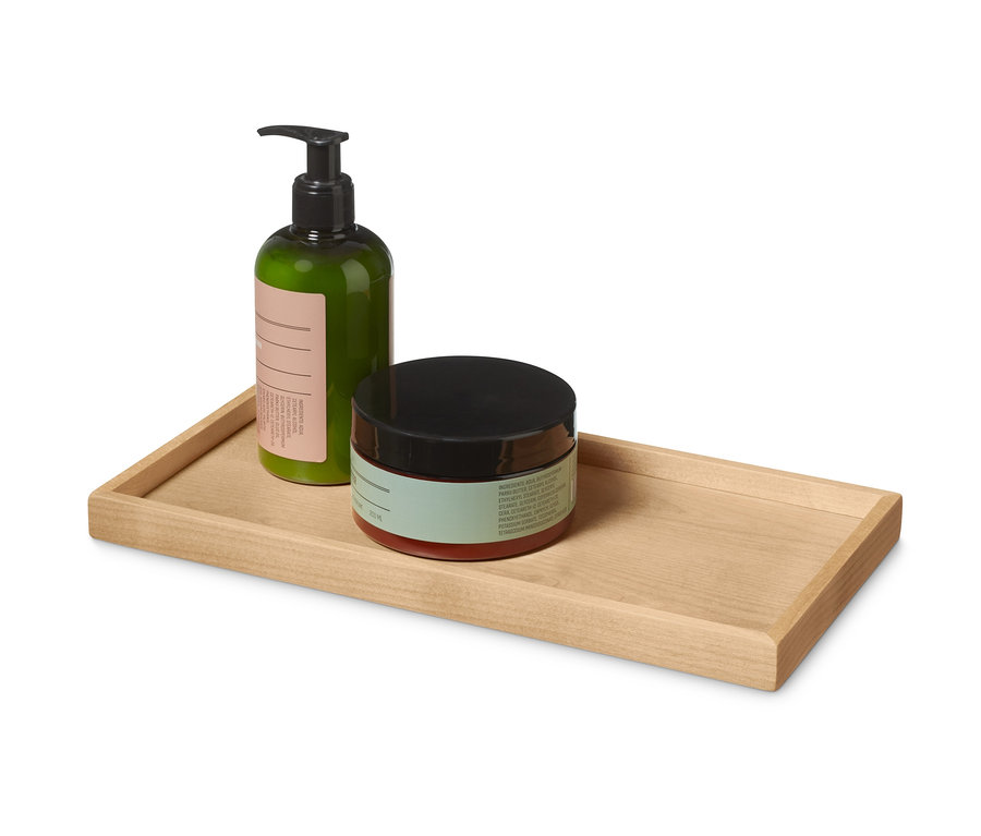 Grüne Flasche und Dose mit schwarzem Deckel auf einem Tablett aus Holz.