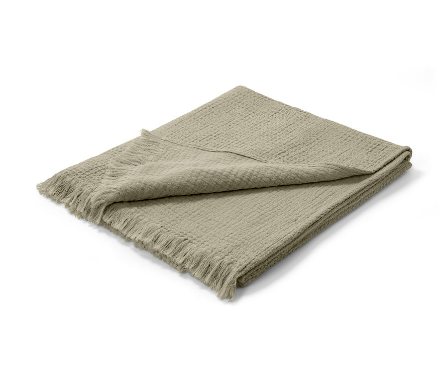 Beige Musselin-Plaid mit Fransen, gefaltet auf einem weißen Hintergrund.
