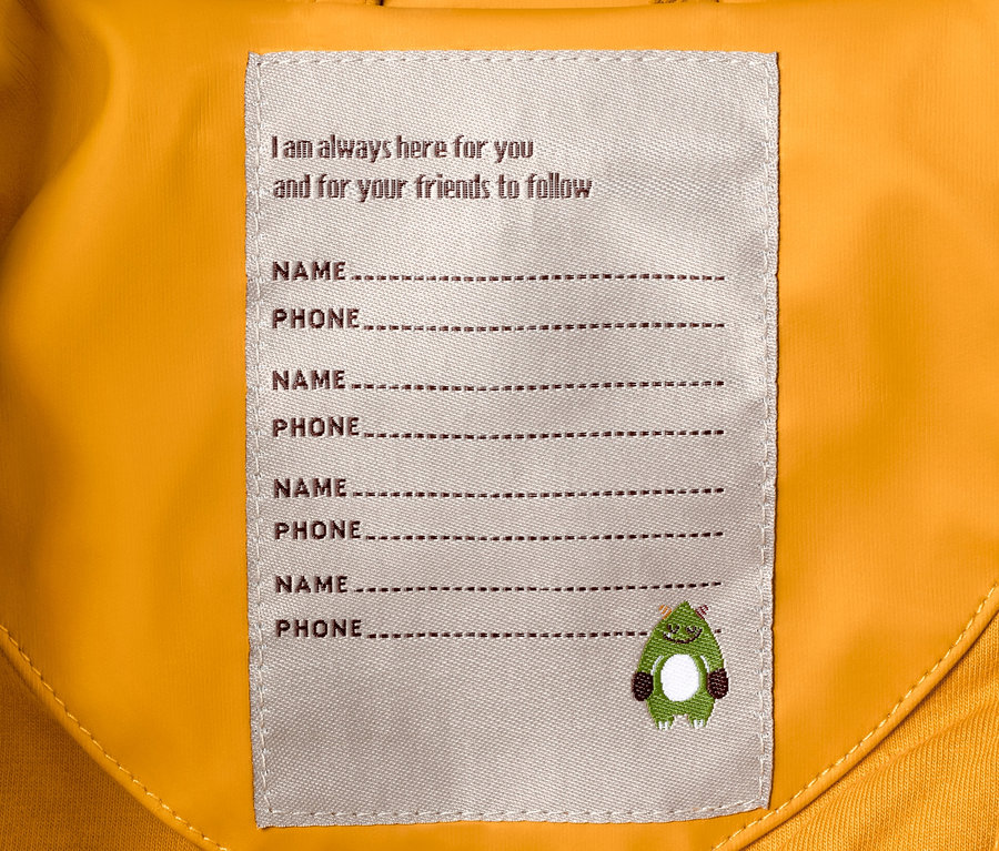 Detailansicht eines gelben Regeneinteilers »Friesennerz« mit einem Etikett für Name und Telefonnummer.