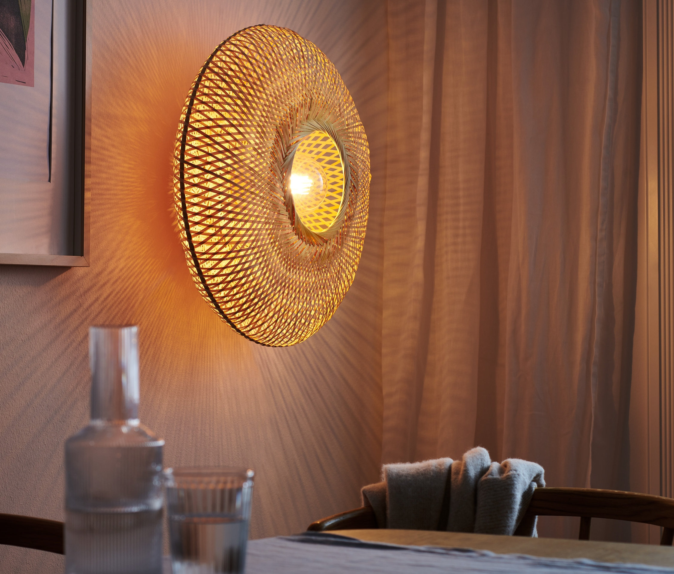 Decken- und Wandleuchte mit Geflechtschirm an der Wand.
