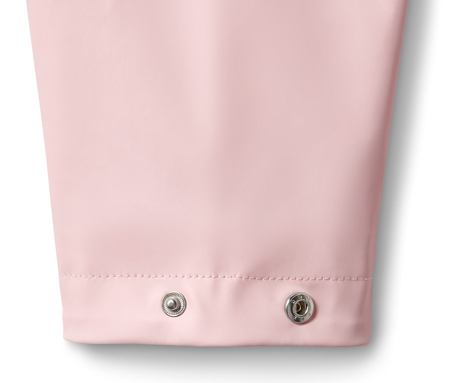 Detailansicht eines rosa Regenparkas mit zwei silbernen Druckknöpfen.