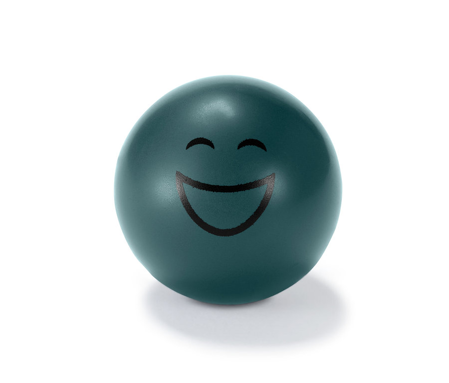Nahaufnahme eines einzelnen grünen Antistressballs mit aufgedrucktem Smiley.