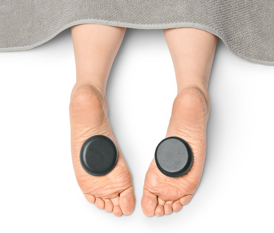 Füße mit Hot Stones Massageset.