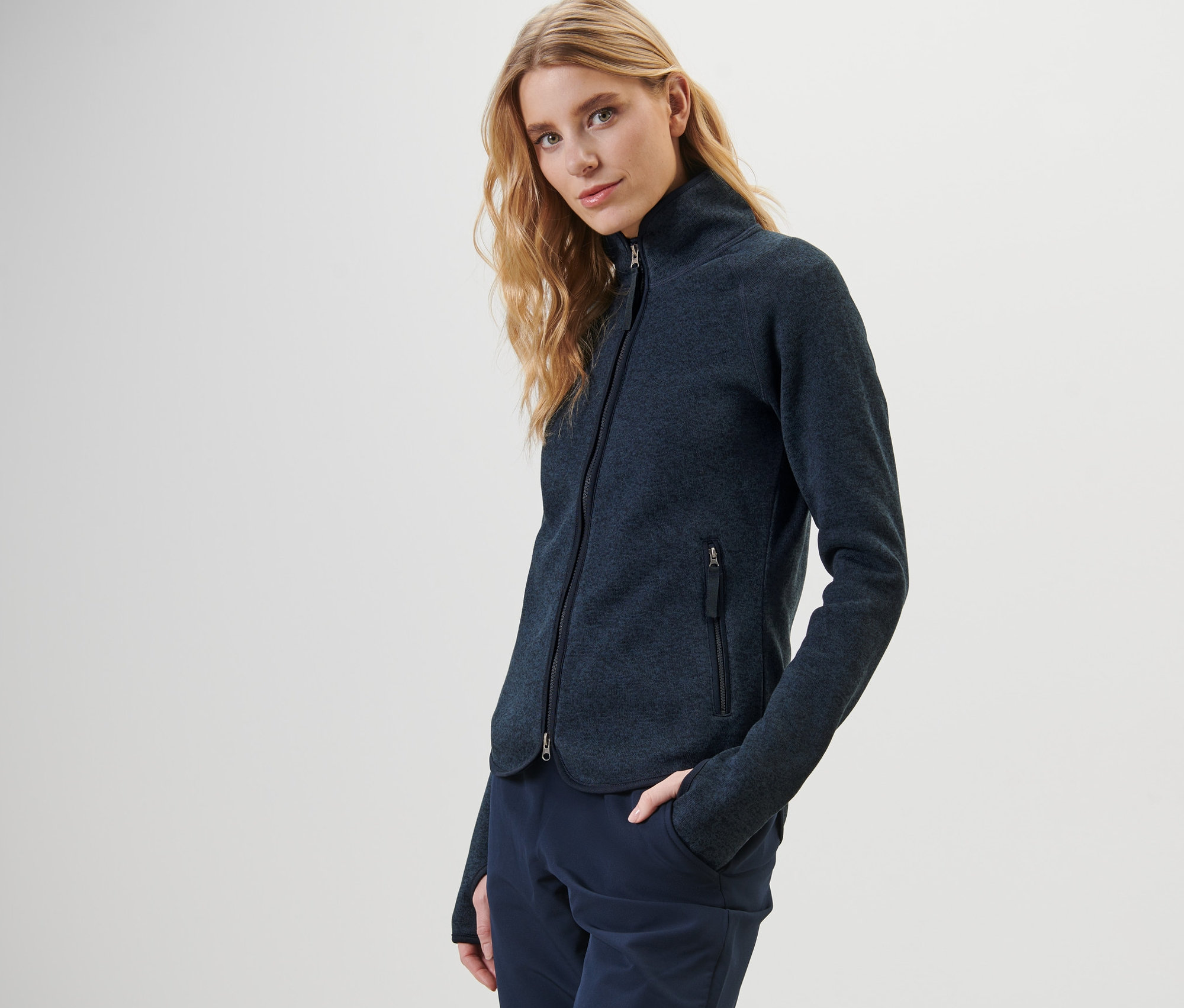 Frau posiert in dunkelblauer Strickfleece-Jacke.