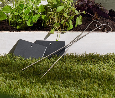 Beet mit Pflanzen, die mit Schiefer-Beetmarkierern gekennzeichnet sind.