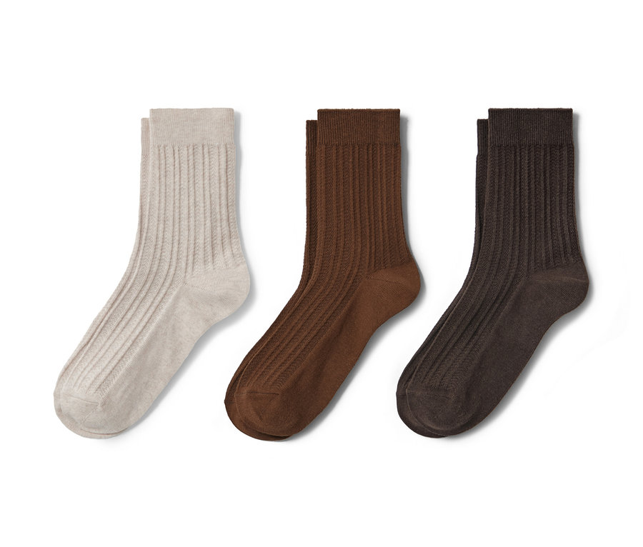Drei Paar Socken mit Zopfmuster in Beige, Braun und Dunkelbraun.