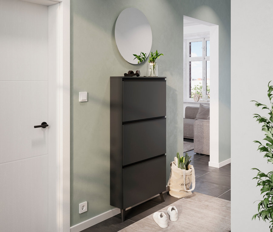 Eingangsbereich mit graphitfarbenem Schuhschrank »Kipper«, Spiegel und weißer Tür.
