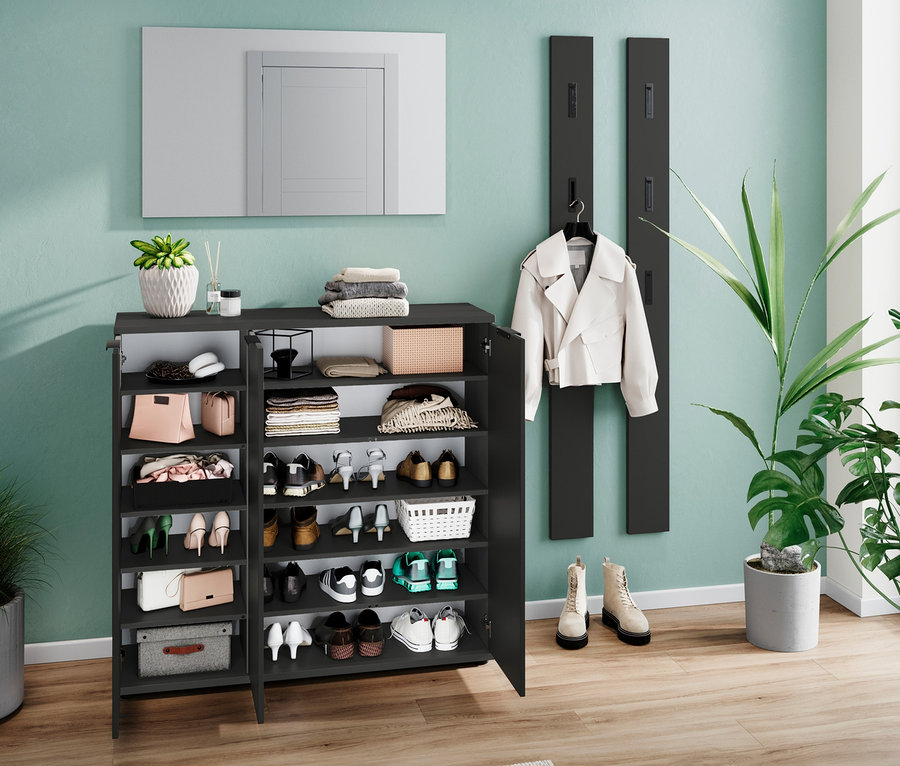 Der schwarze Schuhschrank »Osby« ist teilweise geöffnet, die Regale sind voller Schuhe und Handtaschen.
