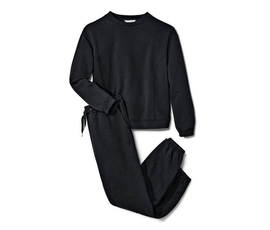 Ein schwarzer Loungewear-Anzug liegt auf einem weißen Hintergrund.