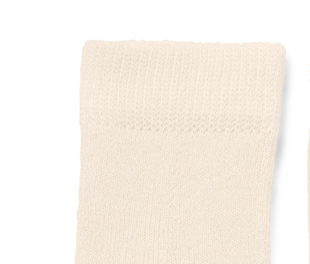 Zwei cremefarbene Babysocken mit blauem Wal-Motiv.