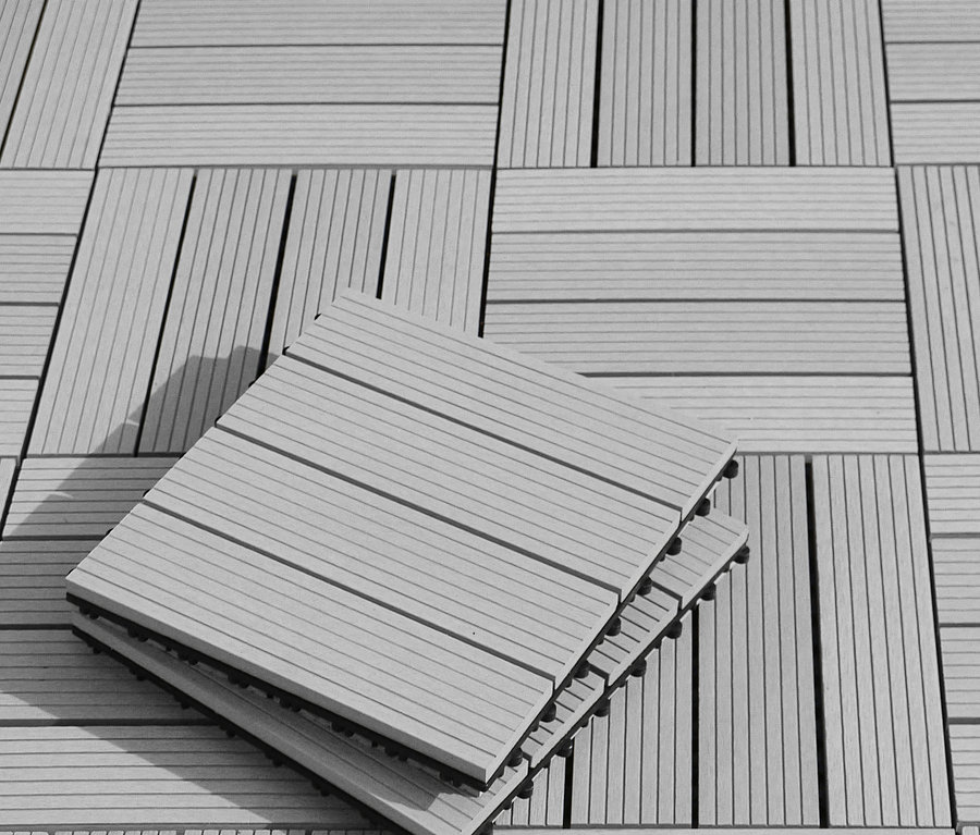 Quadratische, hellgraue 30 x 30 cm Terrassenfliesen, einige davon gestapelt.