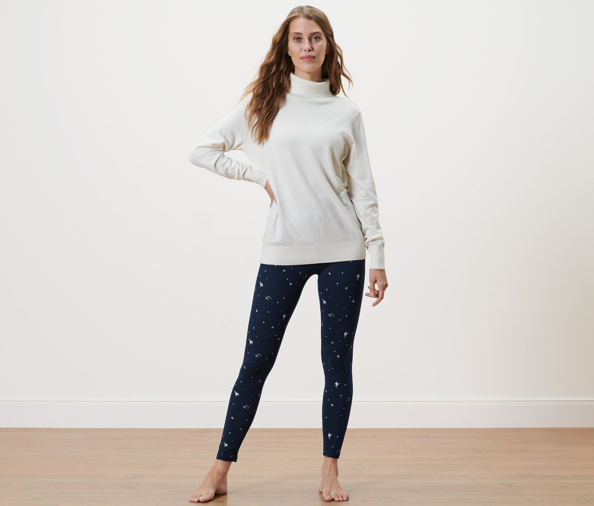 Frau posiert in einem Pullover und einer kuscheligen Leggings.