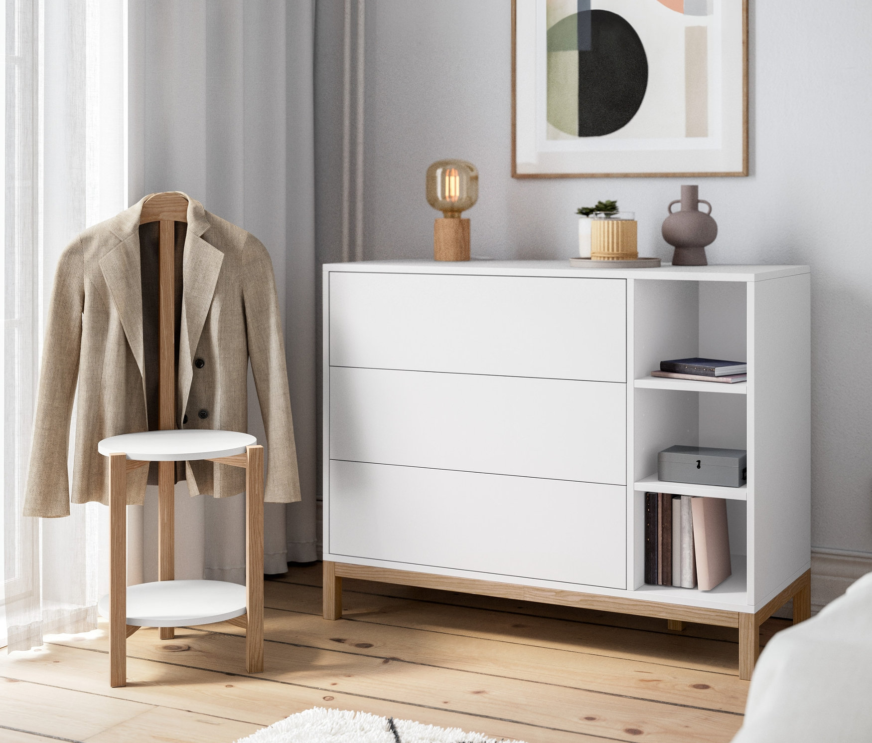 Im Raum stehen eine Kommode, eine Tischleuchte aus Holz und ein stummer Diener.