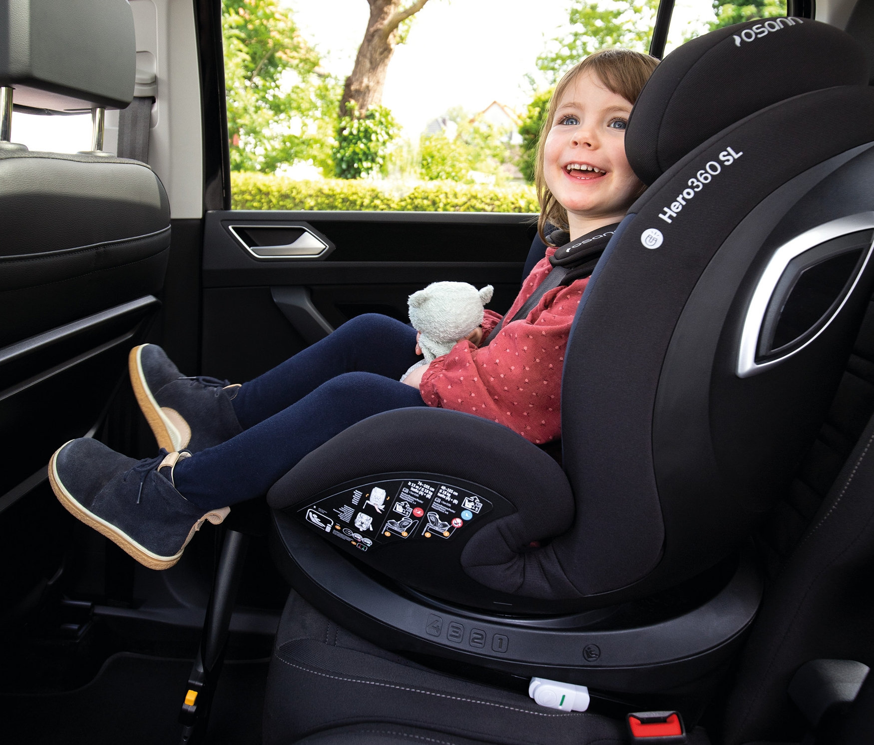 Mädchen sitzt im Osann Kindersitz »Hero360 SL« und lächelt.
