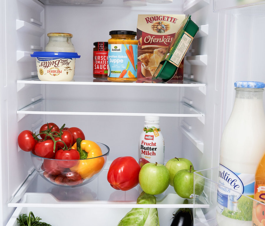 Innenraum eines Kühlschranks gefüllt mit verschiedenen Lebensmitteln, darunter Gemüse, Milchprodukte und Fertiggerichte. Zu sehen ist eine Respekta Kühl-Gefrierkombination »KS144VC«, Vintage Cream.