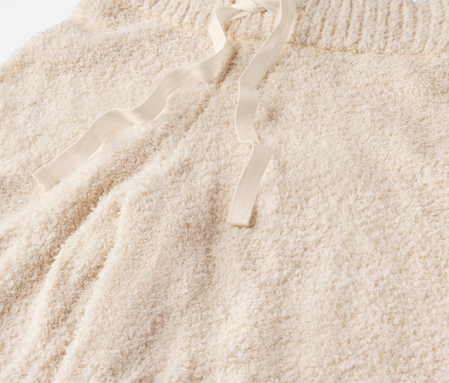 Detailaufnahme von cremefarbenen, flauschigen Shorts mit Kordelzug.