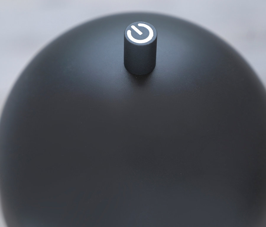 Detailaufnahme einer grauen, kugelförmigen Lampe mit Netzschalter.