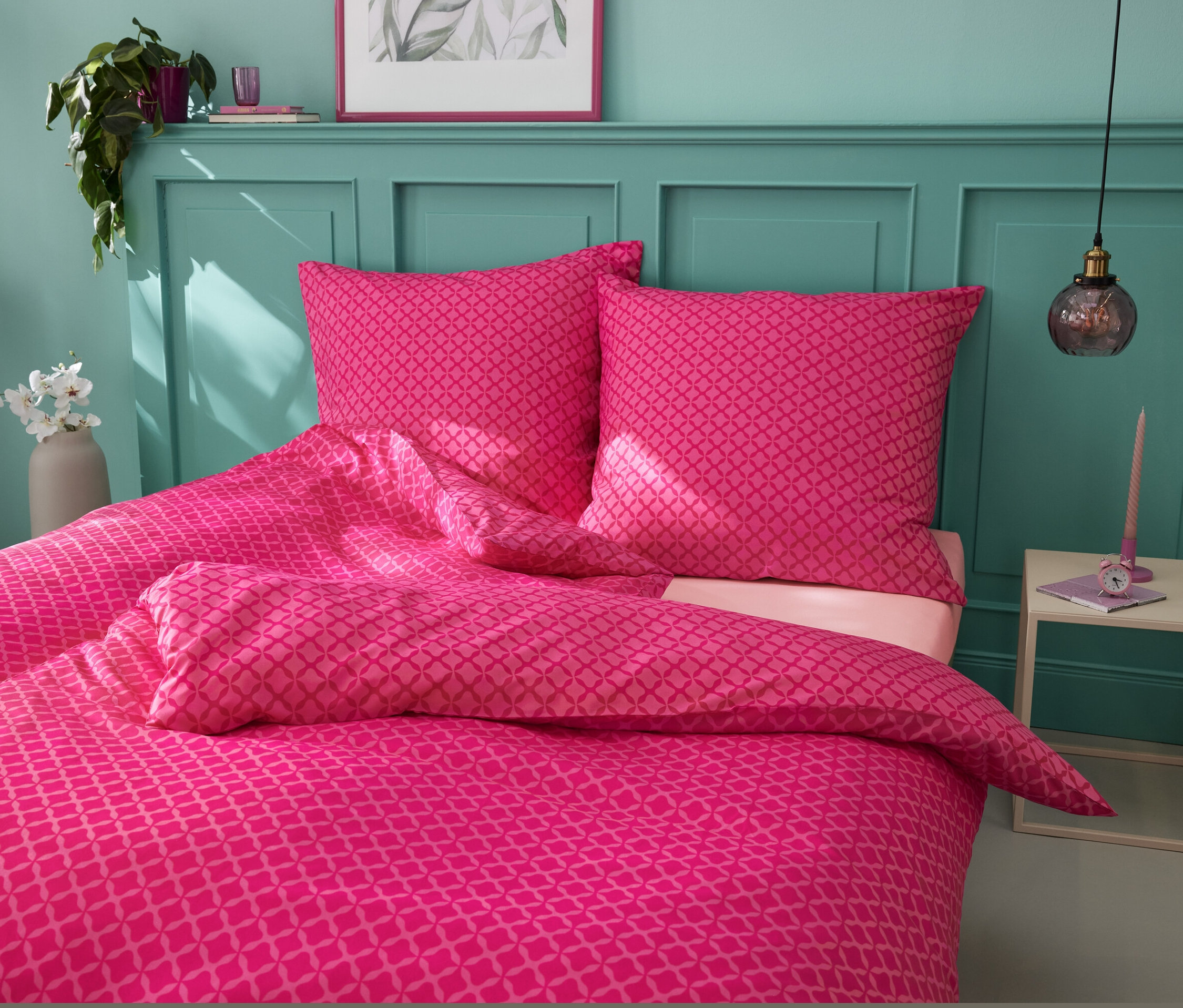 Rosa Microfaser-Bettwäsche in Normal- und Übergröße auf einem Bett.