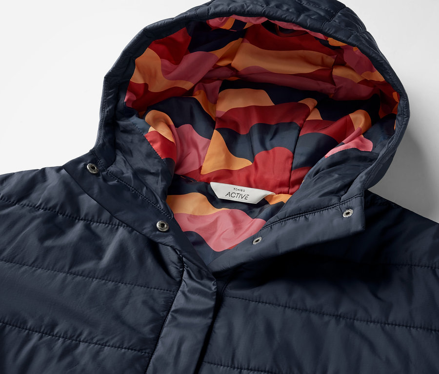 Detailansicht eines blauen Outdoor-Ponchos mit Kapuze und farbigem Muster innen.