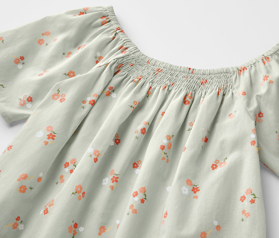 Hellgrüne Kinder-Bluse mit Blumenmuster.