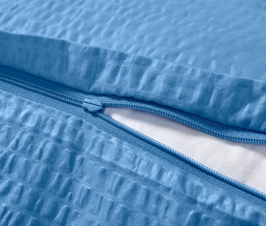 Detailaufnahme von blauem Seersucker-Bettbezug mit Reißverschluss.