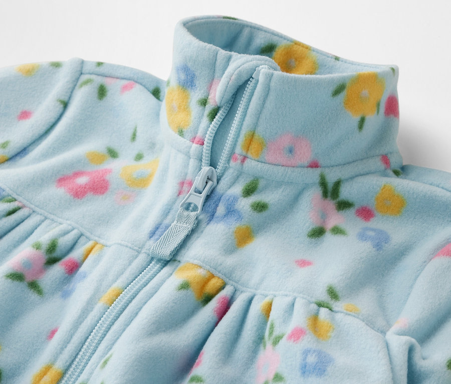 Detailansicht einer Kinder-Fleecejacke mit Reißverschluss und Blumenmuster.