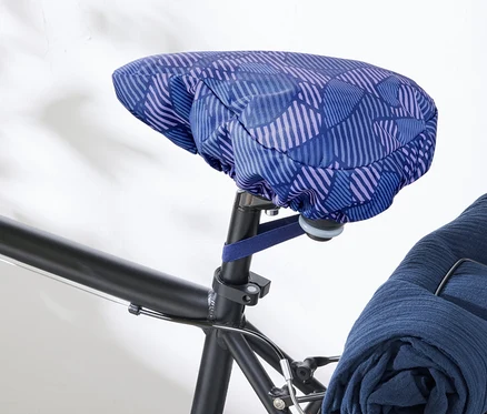 Nahaufnahme eines Fahrrads mit einem blau-lila Fahrrad-Sattelbezug.