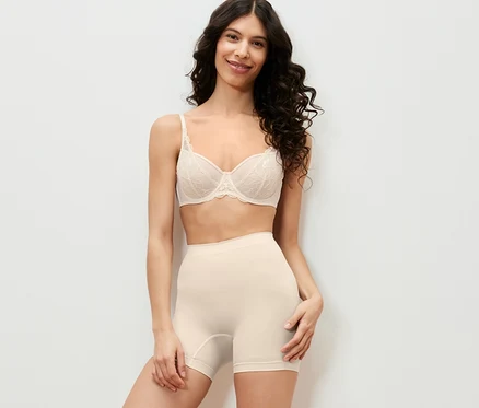 Frau posiert in Unterwäsche und Shaping-Shorts.