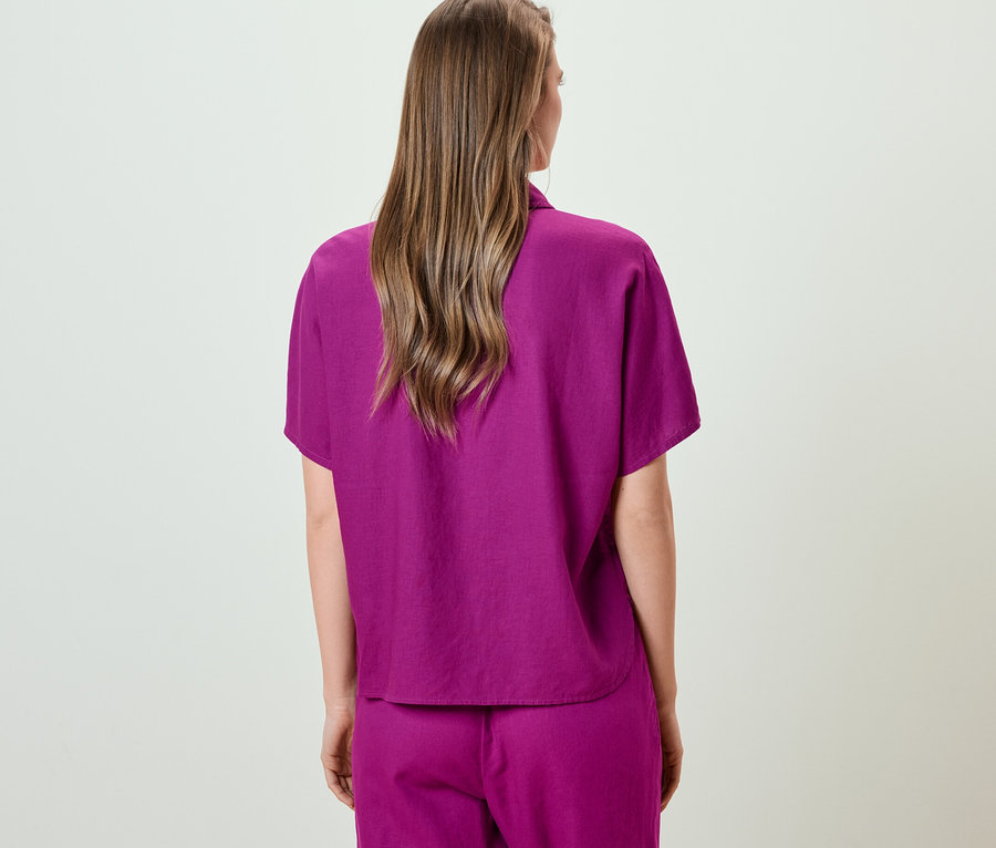 Rückansicht einer Frau in Leinenbluse.