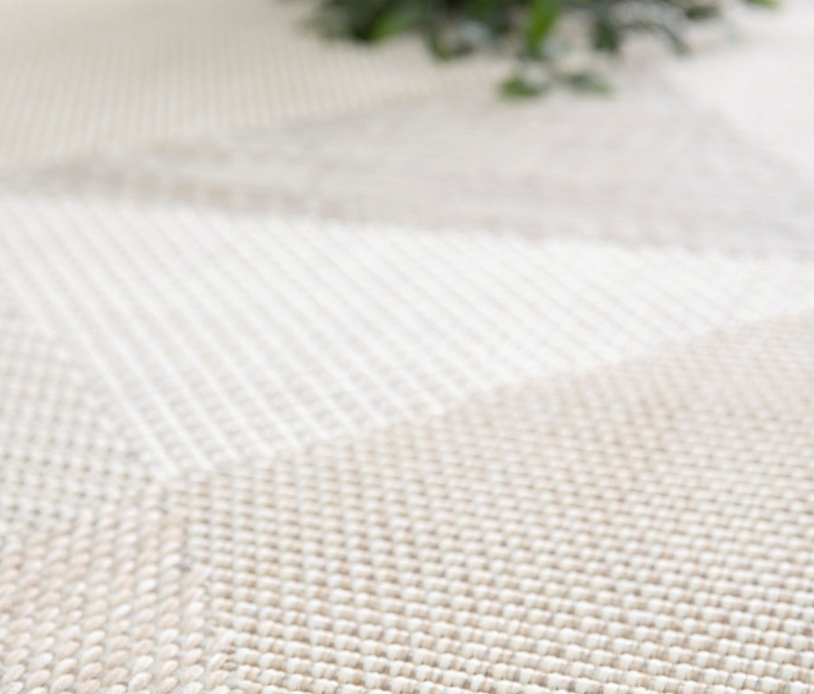 Detailaufnahme eines beigen Outdoor-Teppichs »Sandstone Shapes« mit geometrischem Muster.