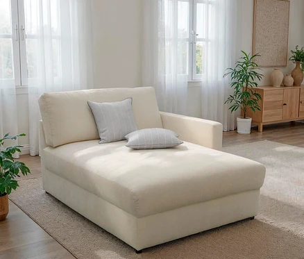 Beige Liege mit Kissen in einem Wohnzimmer.
