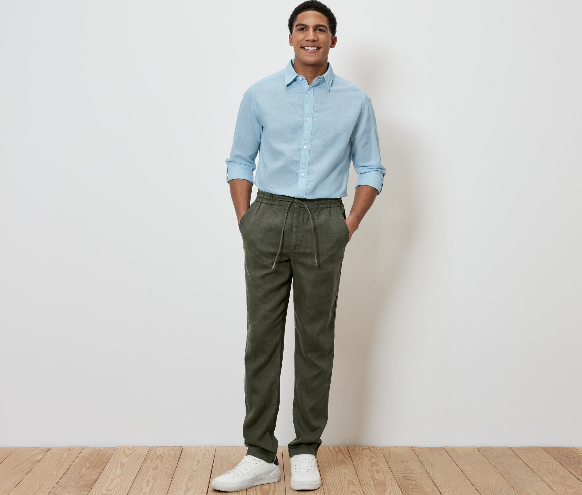 Mann steht mit den Händen in den Taschen der Leinen-Chino, khaki.