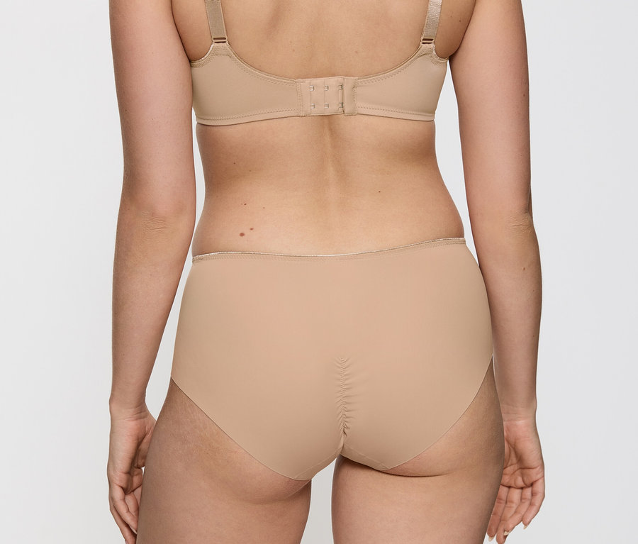 Rückenansicht einer Person, die einen hautfarbenen Triumph Essential #Minimizer W X# BH und passende hochgeschnittene Slips mit Raffung am Rücken trägt.