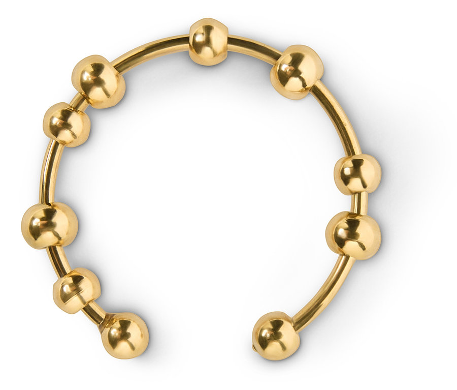 Goldener Armreif mit Kugeln auf weißem Hintergrund.