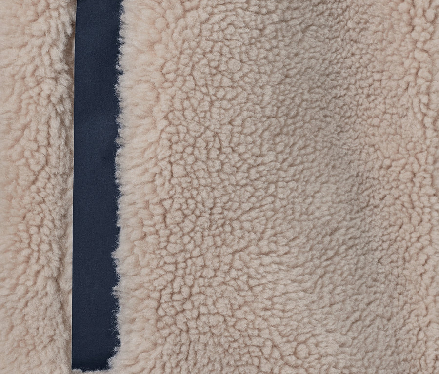 Detail einer Teddyplüschjacke mit dunkelblauem Rand.