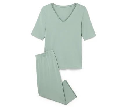 Ein hellgrüner Pyjama, bestehend aus einem kurzärmeligen Oberteil und einer Hose, liegt auf einem weißen Hintergrund.