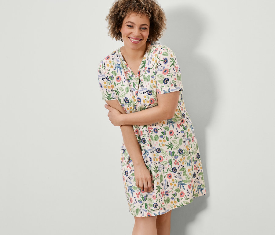 Frau posiert in einem Nachthemd mit Blumenmuster.