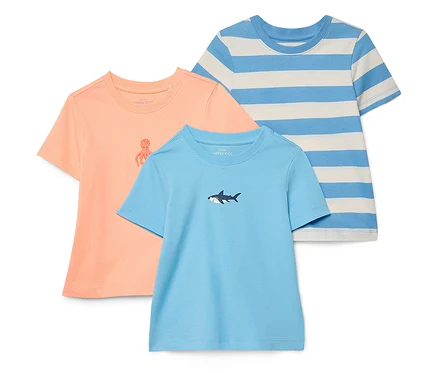 Drei T-Shirts liegen übereinander: ein oranges mit einem Tintenfisch, ein blaues mit einem Hai und ein blau-weiß gestreiftes.