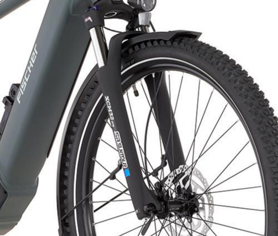 Nahaufnahme vom Vorderrad eines FISCHER ATB E-Bike TERRA 6.8i ULTIMATE, 55 cm, mit Fokus auf Reifen, Speichen und Federgabel.