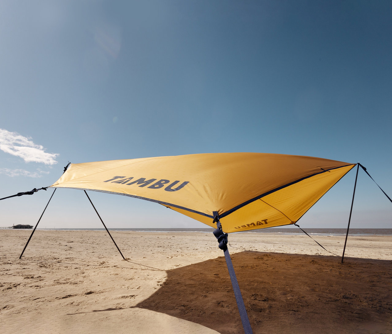 Gelbes Tambu »PALA« Tarp/Sonnensegel ist am Strand aufgestellt.