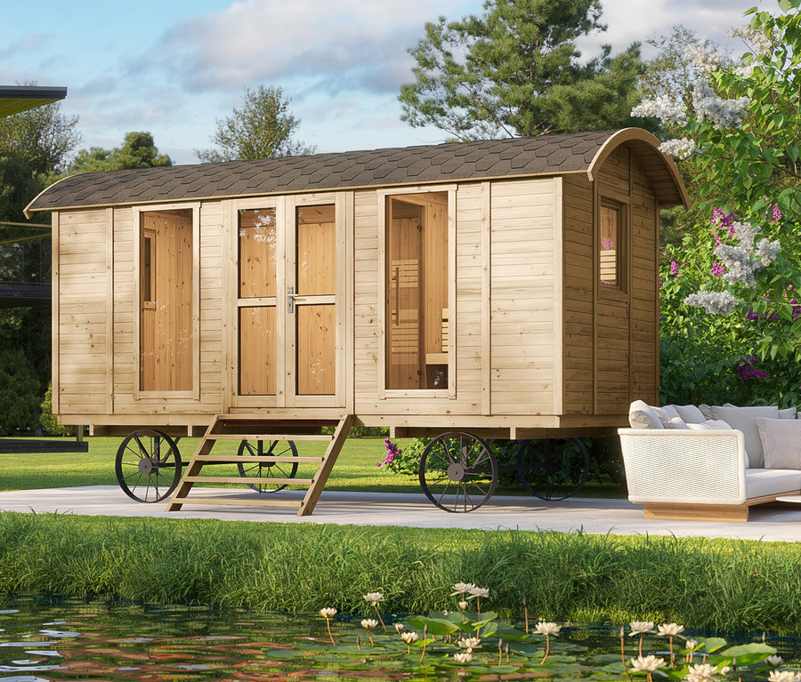 Holzsauna-Wagen mit Rädern auf Rasen neben einem Teich mit Seerosen.