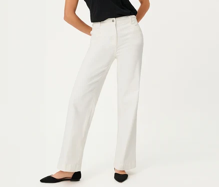 Frau trägt Olsen Wide Leg Jeans und schwarze Schuhe vor einem weißen Hintergrund.