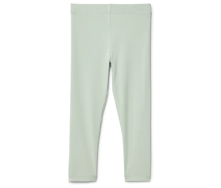 Eine hellgrüne Leggings liegt auf einem weißen Hintergrund.