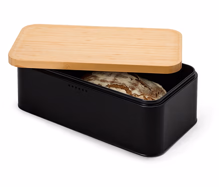 Ein Laib Brot liegt in einem schwarzen Brotkasten mit einem hellbraunen Holzdeckel, der teilweise geöffnet ist.