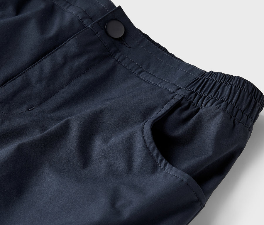 Nahaufnahme von marineblauen Hosen mit Knopf und elastischem Bund.