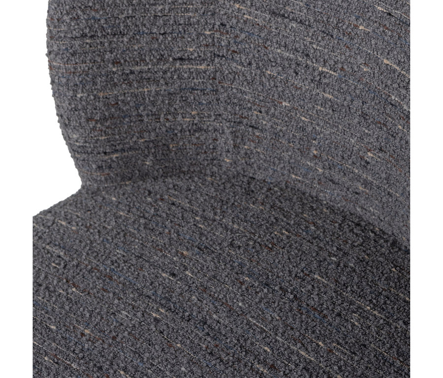 Nahaufnahme eines dunkelgrauen, strukturierten Stoffes, möglicherweise Bouclé, mit beigen, blauen und braunen Sprenkeln, der eine gekrümmte Oberfläche zeigt.